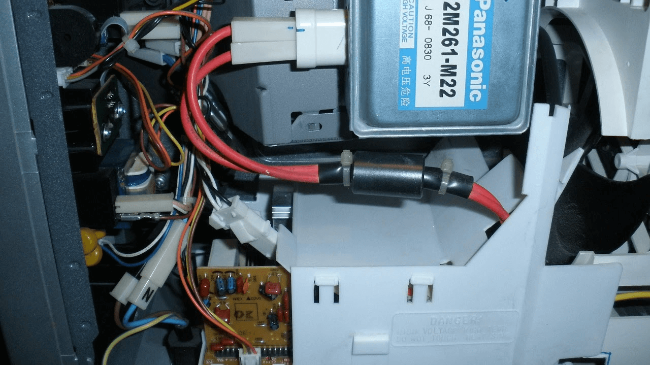 Wnętrze mikrofalówki Panasonic z widocznym inwerterem i magnetronem