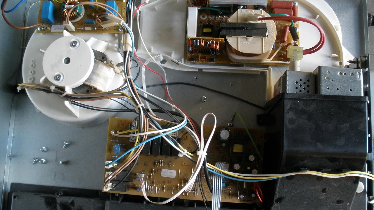 Wnętrze mikrofalówki do zabudowy Whirlpool - widoczny sterownik, inwerter i magnetron w mikrofalówce Whirlpool